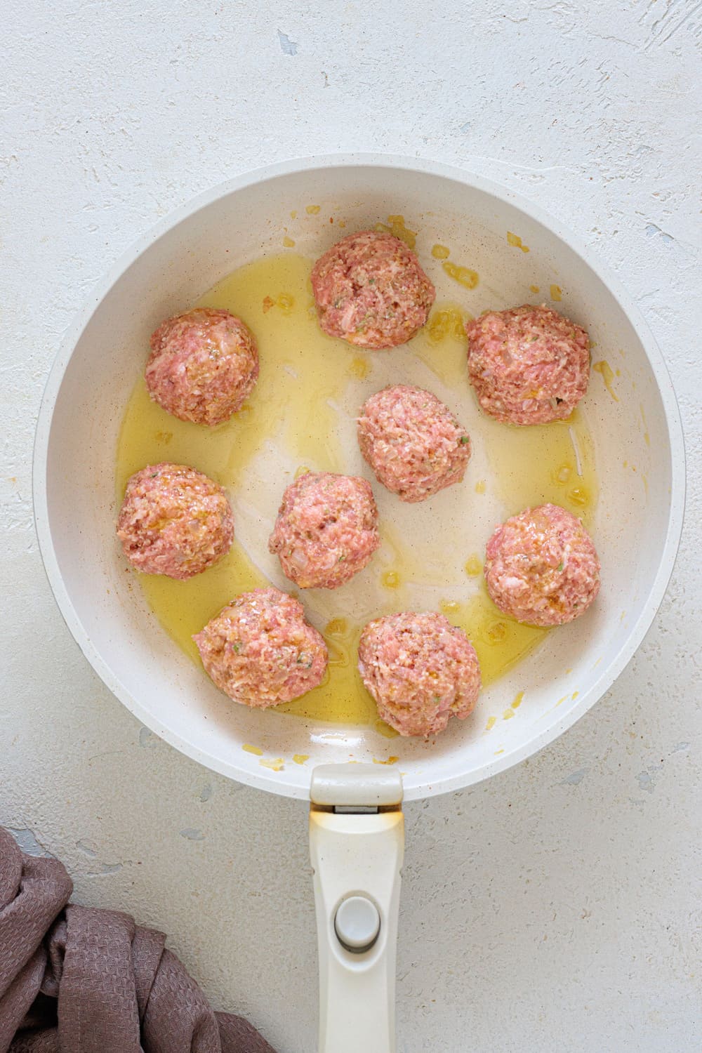 Roll the meatballs and add them to the pan with a drizzle of olive oil.