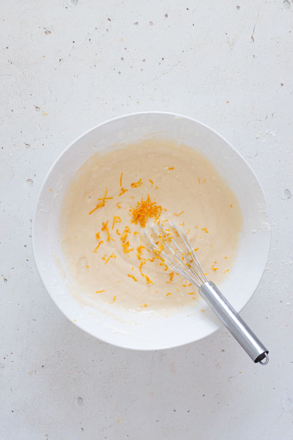 After adding the flower and baking powder and mixing until smooth, add the orange zest and mix one last time.