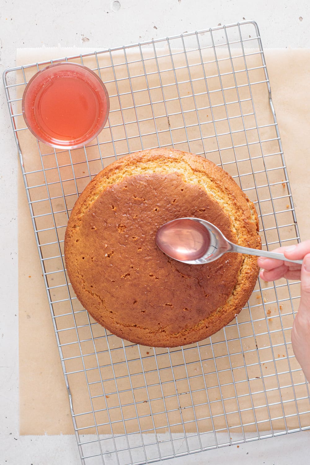 When the cake comes out, let it sit for a few minutes and then poke small holes across the surface and slowly pour the syrup over